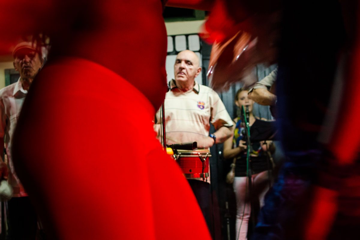 cuban musician looking to a beautiful girl in vinales, by louis alarcon, street photographer