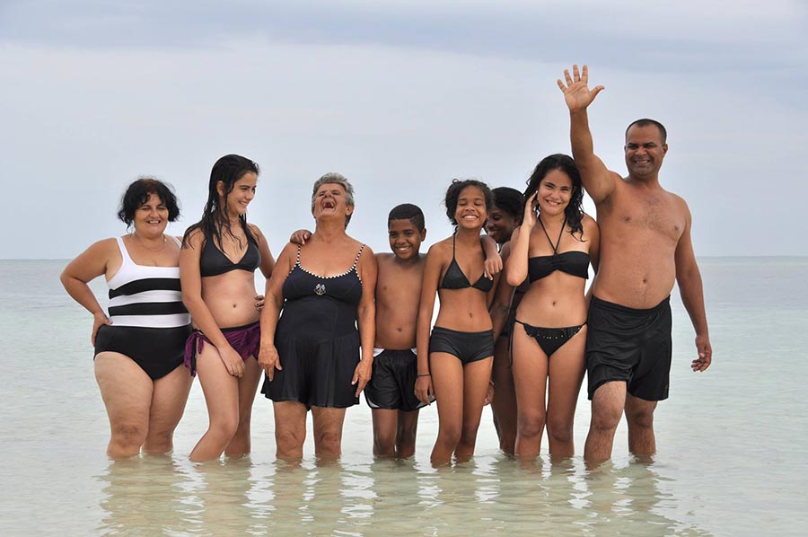 family in cuban beach saying hello to my students in my photography tour to east of cuba