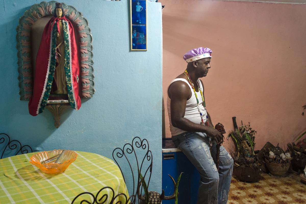 afrocuban priest in his house with saints in havana , cuban photo workshop