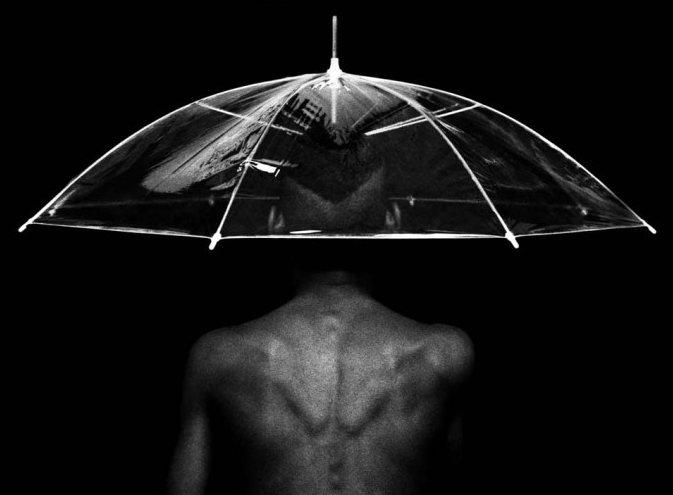 black nude man under the umbrella. Cuban photography by rene peña