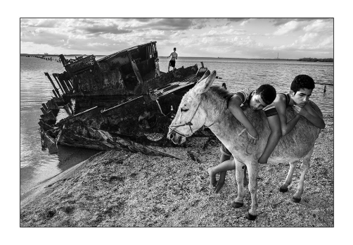 boys over a donkey taken by raul canibano cuban documentary photographer