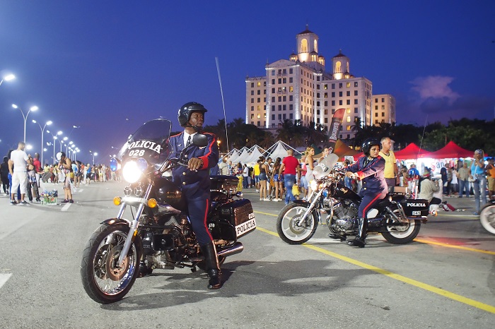 police riding a motorbycle under the national hotel in Havana